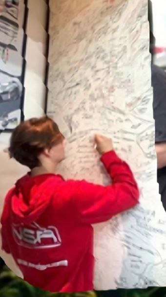 Young racer signing the wall