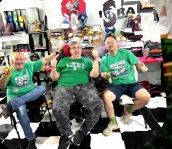 Racers in green shirts at the track